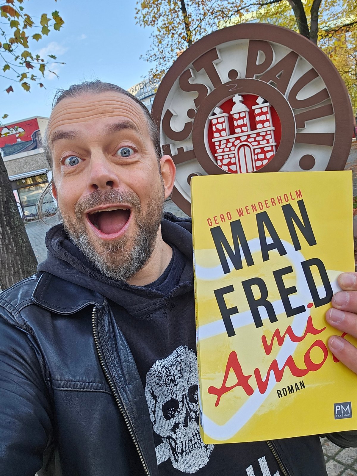 Gero Wenderholm mit seinem Roman Manfred mi Amor vor dem FC-St.-Pauli-Logo am Tag des Erscheinens
